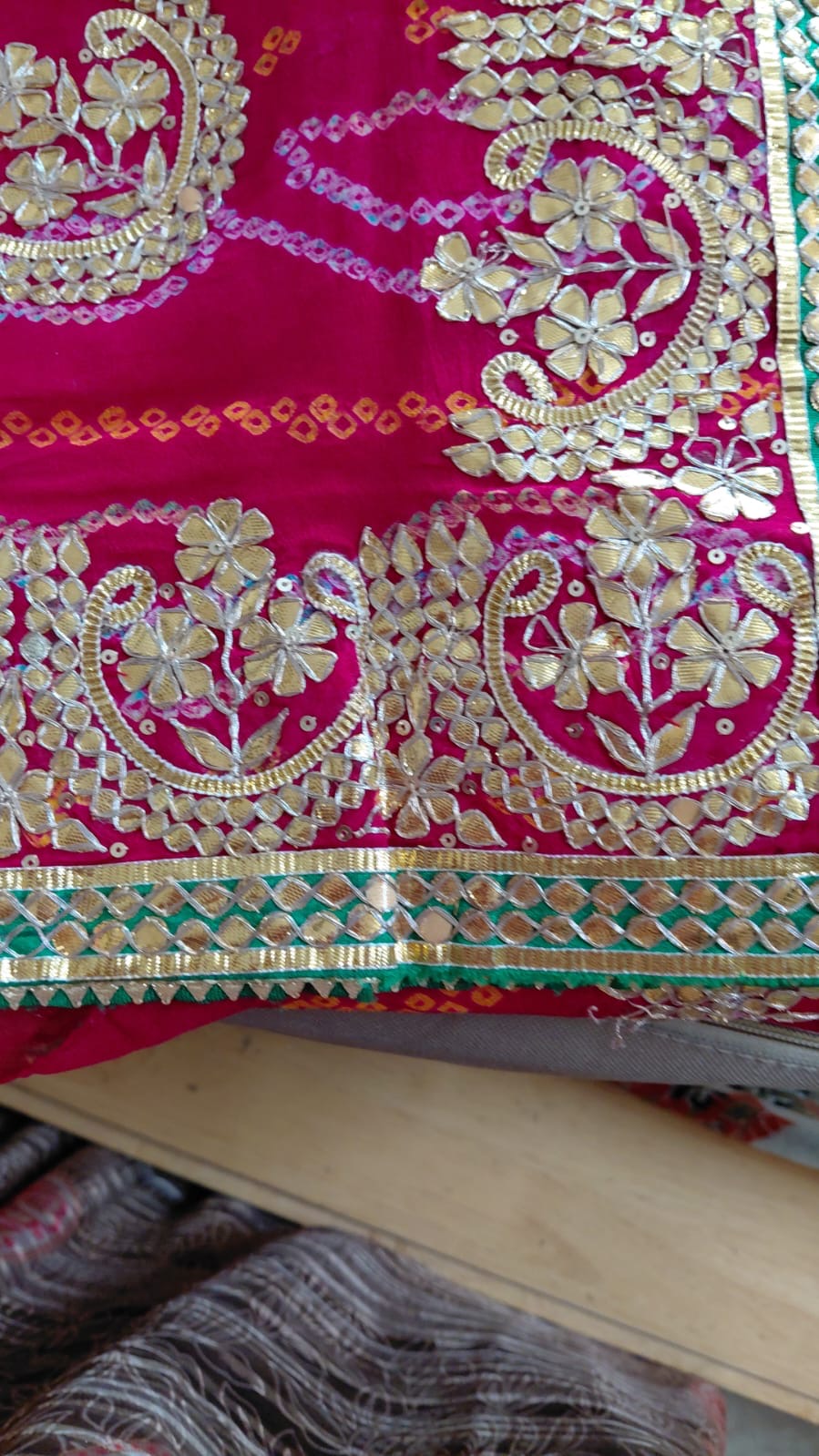 Gold-toned peacock forms and a green accent along a richly decorated pink border.